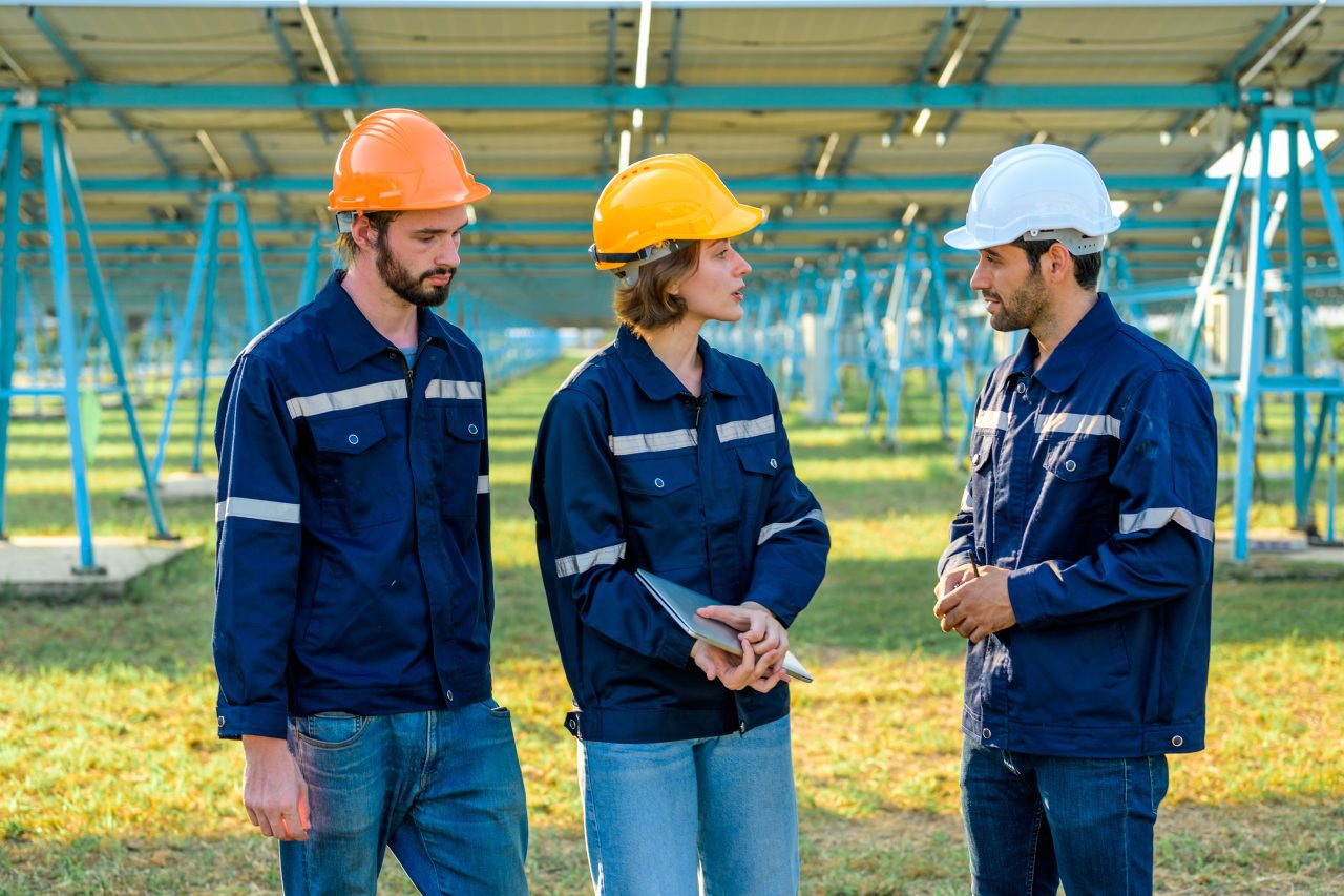 Workers installing solar panels at a solar farm